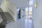 Flur mit Treppe/Aufzug - Lichtdurchflutete, barrierearme Wohnung im Stadtzentrum von Aurich!