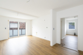 Wohnbereich/ Wohnküche - Stilvolle 3-Zimmer-Wohnung im Neubau, 1. OG – Aufzug, Balkon & Ortskernlage
